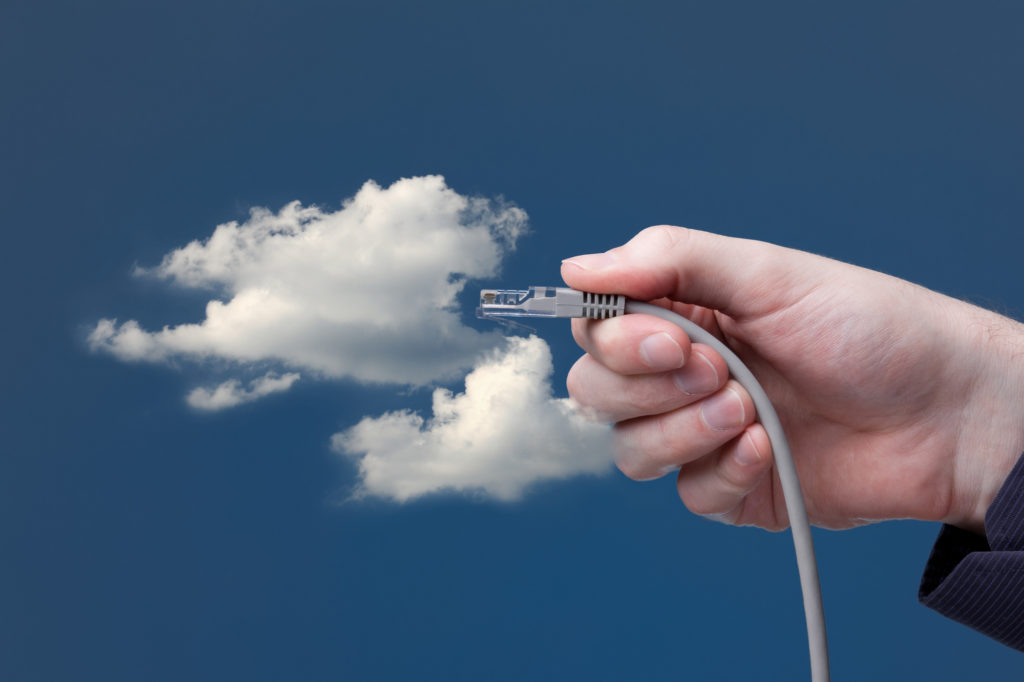 Cloud computing concept. Hand with ethernet cable connecting into cloud.